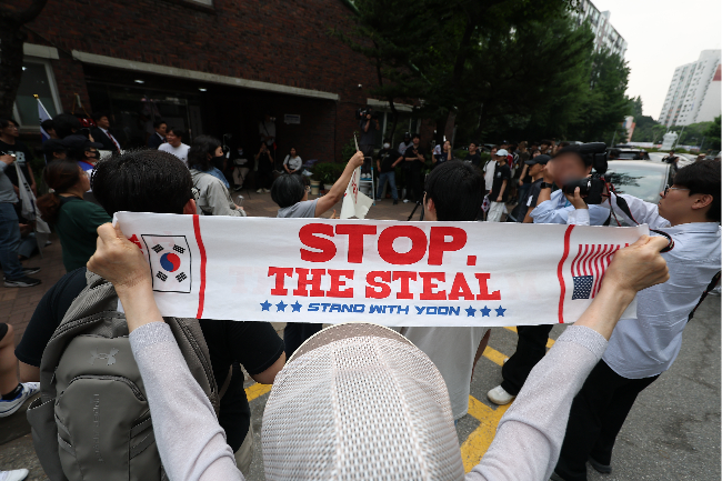 Citizens hold a protest outside of a polling station in Jamsil-dong, Songpa-gu, Seoul, Thursday, blocking the votes from being taken by the National Election Commission. (Yonhap)