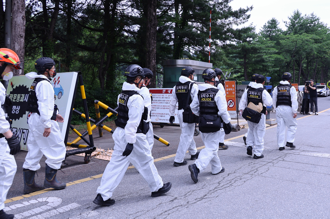 Police officials enter a Hanwha Aerospace factory in Daejeon on Tuesday to conduct an on-site inspection a day after a deadly explosion at the site. (Yonhap)