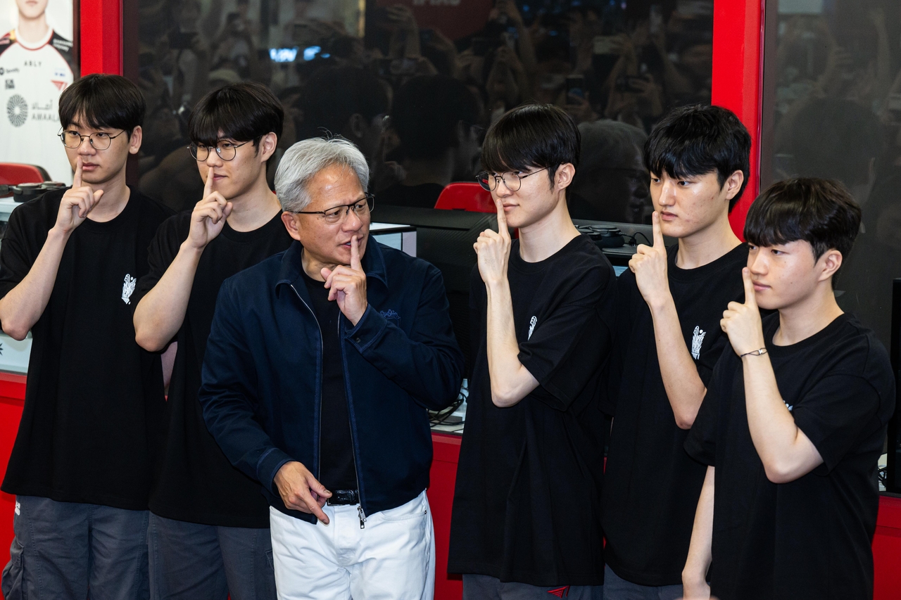 Nvidia CEO Jensen Huang (second from left) strikes Lee "Faker" Sang-hyeok's (center) signature pose as he meets members of esports organization T1's League of Legends team at T1 Base Camp in Mapo-gu, Seoul, Friday. (Yoon Chang-bin/The Korea Herald)