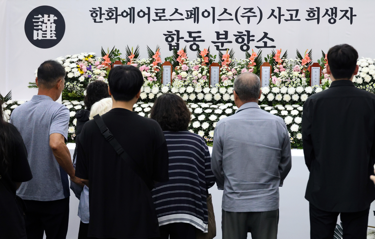 Bereaved family members of the victims of the explosion at Hanwha Aerospace's Daejeon facility pay tribute at a joint memorial altar set up at the Yuseong District Office in Daejeon on Friday. (Yonhap)