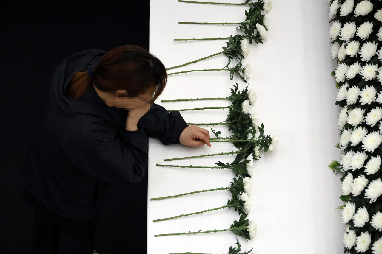 A bereaved family member pays tribute to a victim of the explosion at Hanwha Aerospace's Daejeon facility at a joint memorial altar set up at the Yuseong District Office in Daejeon on Friday. (Yonhap)