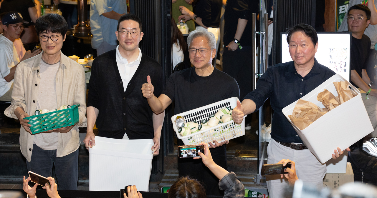(From left) Naver Chairman Lee Hae-jin, LG Group Chairman Koo Kwang-mo, Nvidia CEO Jensen Huang,  and SK Group Chairman Chey Tae-won hands out snacks to onlookers during a "samso" gathering at a restaurant in Mapo-gu, Seoul, Friday.  (Yoon Chang-bin/The Korea Herald)