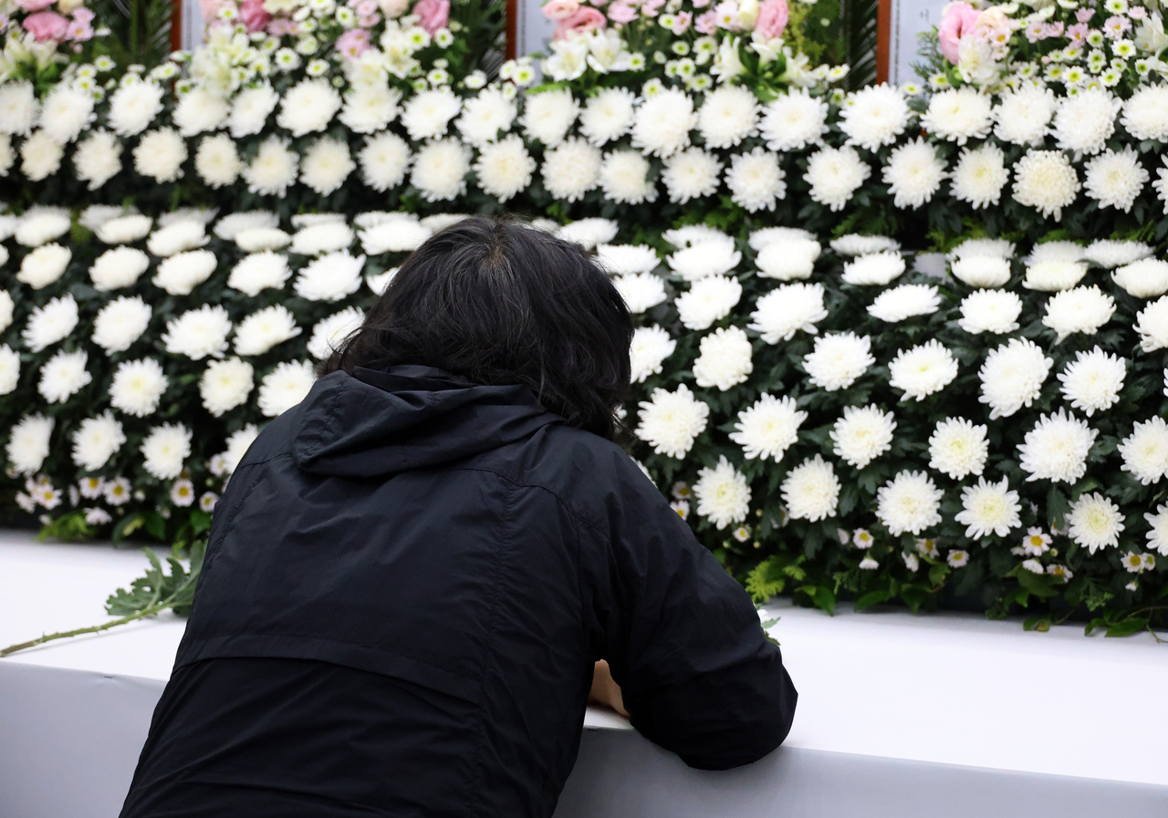A bereaved family member of a victim of the explosion at Hanwha Aerospace’s Daejeon facility cries out in grief at a joint memorial altar set up at the Yuseong District Office in Daejeon on Friday (Yonhap)