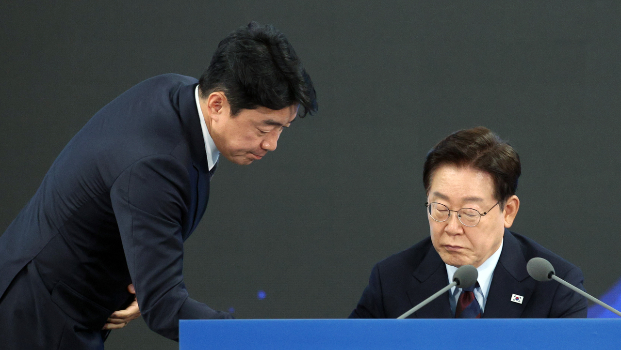 President Lee Jae Myung listens to a report from Presidential Chief of Staff Kang Hoon-sik during the inaugural meeting of the Committee on Future Defense Strategy in Jinhae-gu, Changwon, South Gyeongsang Province, on May 26. (Yonhap)