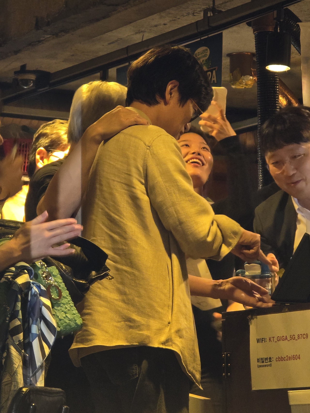 Naver Chairman Lee Hae-jin (center) pays the bill using a Naver Pay Connect payment terminal during a dinner gathering with Nvidia CEO Jensen Huang, SK Group Chairman Chey Tae-won and LG Group Chairman Koo Kwang-mo at a pork belly restaurant in Seoul’s Hongdae neighborhood on Thursday. (Pool photo)