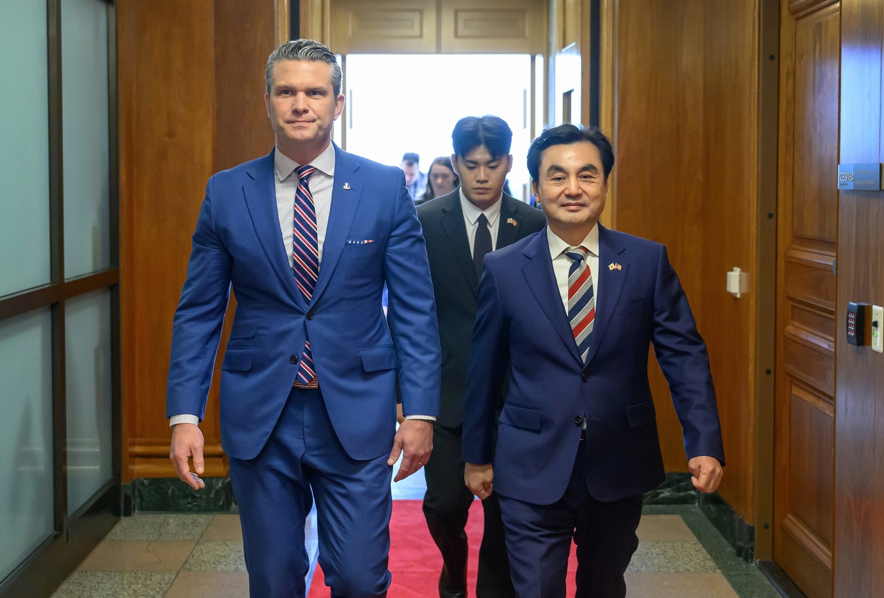 Defense Minister Ahn Gyu-back (right) and US Defense Secretary Pete Hegseth walk to a meeting room at the Pentagon in Washington on May 11. (Ministry of National Defense via Yonhap)