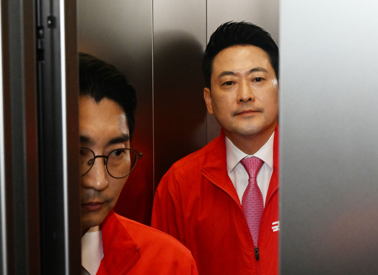 People Power Party Chair Rep. Jang Dong-hyeok (right) leaves the party's election situation room at its headquarters in Yeouido, Seoul, on Wednesday after watching exit poll results for the ninth nationwide local elections. (National Assembly Joint Press Corps)