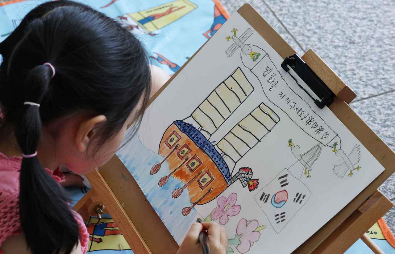 A child draws a picture during a drawing contest held at the War Memorial of Korea in Yongsan-gu, central Seoul on Saturday. (War Memorial of Korea)