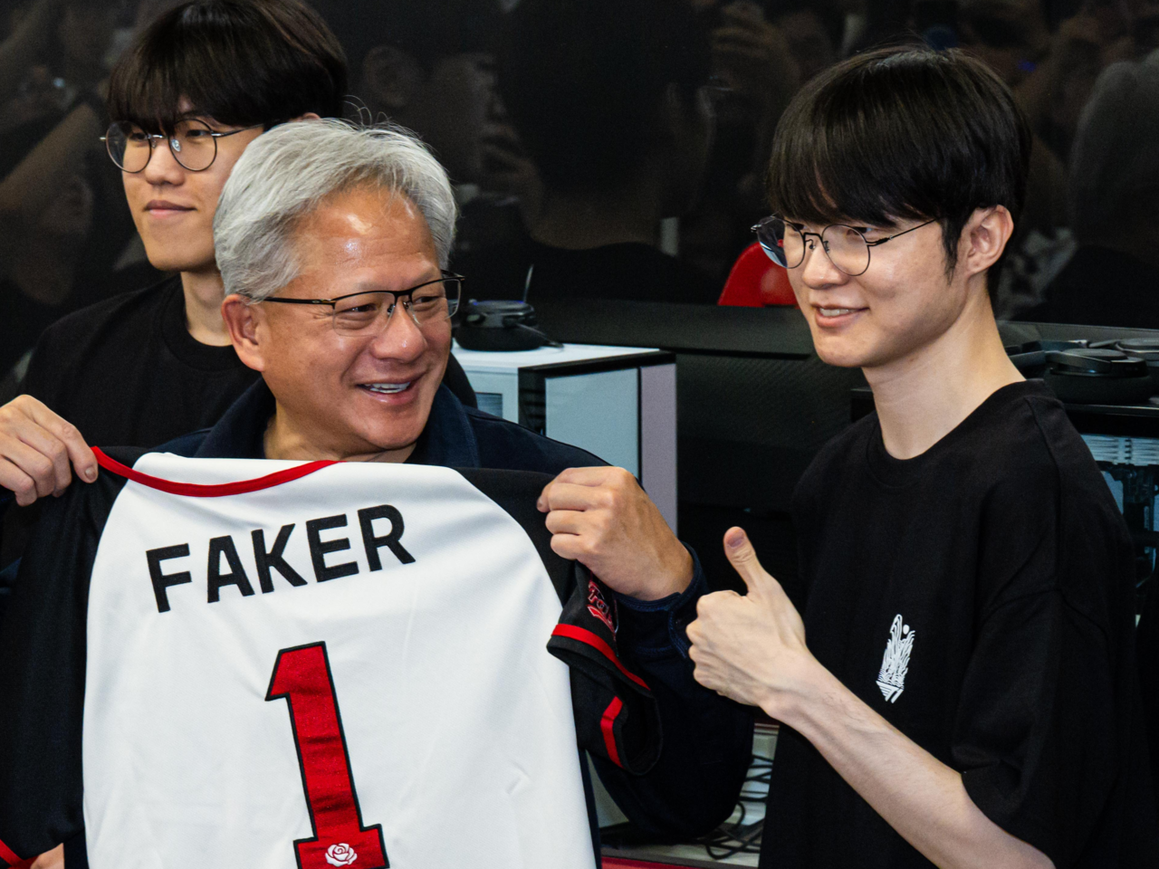Nvidia CEO Jensen Huang (center) receives a souvenir signed by Lee "Faker" Sang-hyeok as he meets members of esports organization T1's League of Legends team at T1 Base Camp in Mapo-gu, Seoul, Friday. (Yoon Chang-bin/The Korea Herald)
