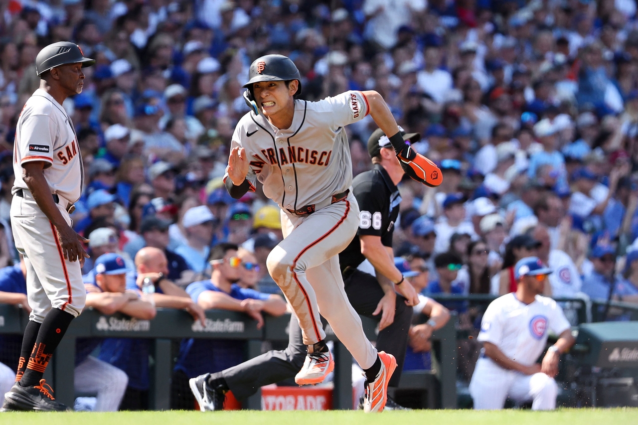 Lee Jung-hoo of the San Francisco Giants (R) scores on a sacrifice fly by Matt Chapman during a Major League Baseball regular-season game against the Chicago Cubs at Wrigley Field in Chicago on Saturday. (Getty Images)