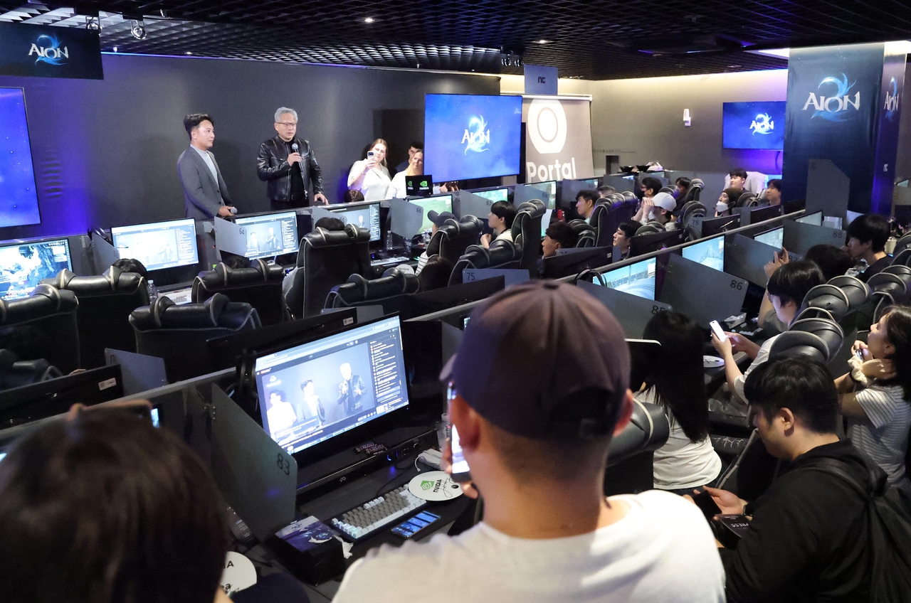 Nvidia CEO Jensen Huang speaks to gamers at a PC gaming cafe in Seoul on Sunday. (Joint Press Corp.)