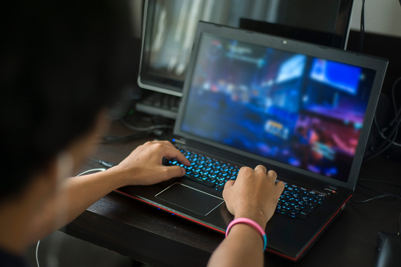 A man plays a game on a laptop in this file photo. This image is not directly related to the story. (123rf)