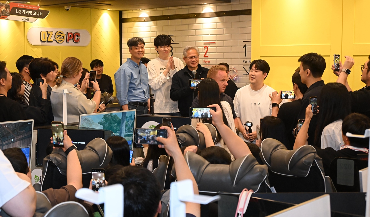 Nvidia CEO Jensen Huang speaks to gamers at a PC gaming cafe in Seoul on Sunday. (Joint Press Corp.)