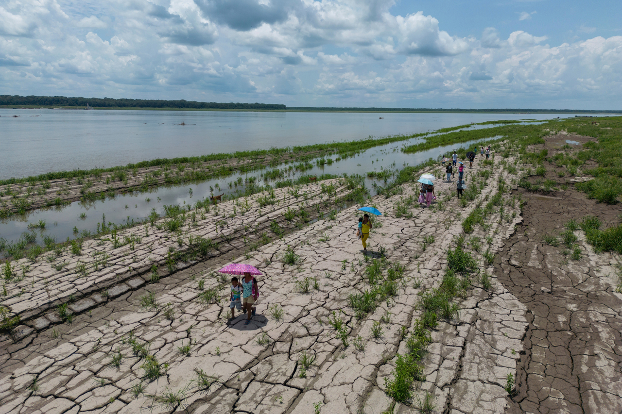 People walk through a part of the Amazon River that shows signs of drought in Santa Sofia, Colombia, in October 2024. (AP-Yonhap)