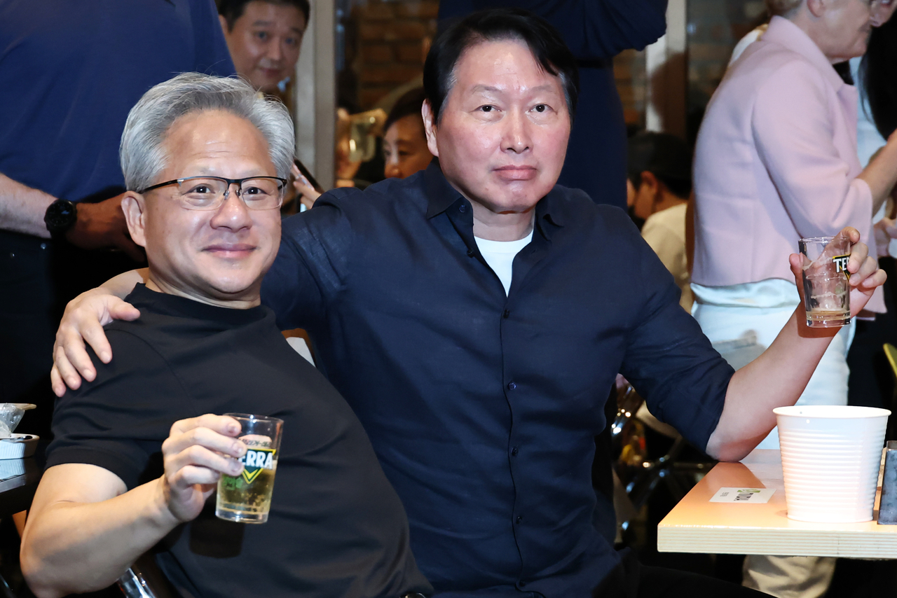 Nvidia CEO Jensen Huang (left) and SK Group Chairman Chey Tae-won raise their glasses during a fried chicken-and-beer dinner at Kkanbu Chicken in Samseong-dong, southern Seoul, on Sunday. (Yonhap)