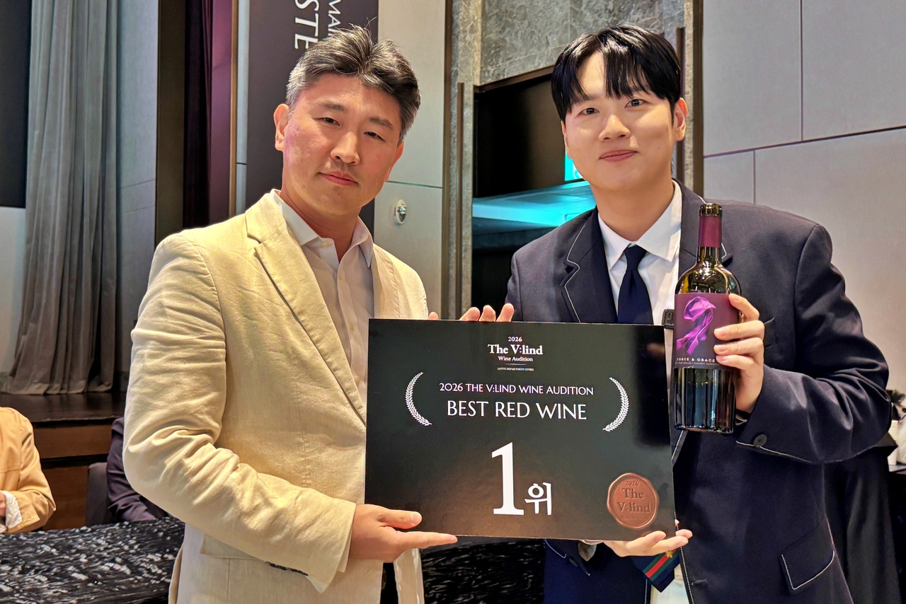 5일 서울 송파구 시그니엘 서울의 76층에서 개최된 ‘더 블라인드 2026’에서 송재형(왼쪽부터) 나라셀라 상무와 심사위원인 래퍼 한해가 레드 와인 1위 수상작인 ‘포스&그레이스 파소 로블스 카베르네 소비뇽 2023’을 들고 기념사진을 촬영하고 있다. [롯데백화점 제공]