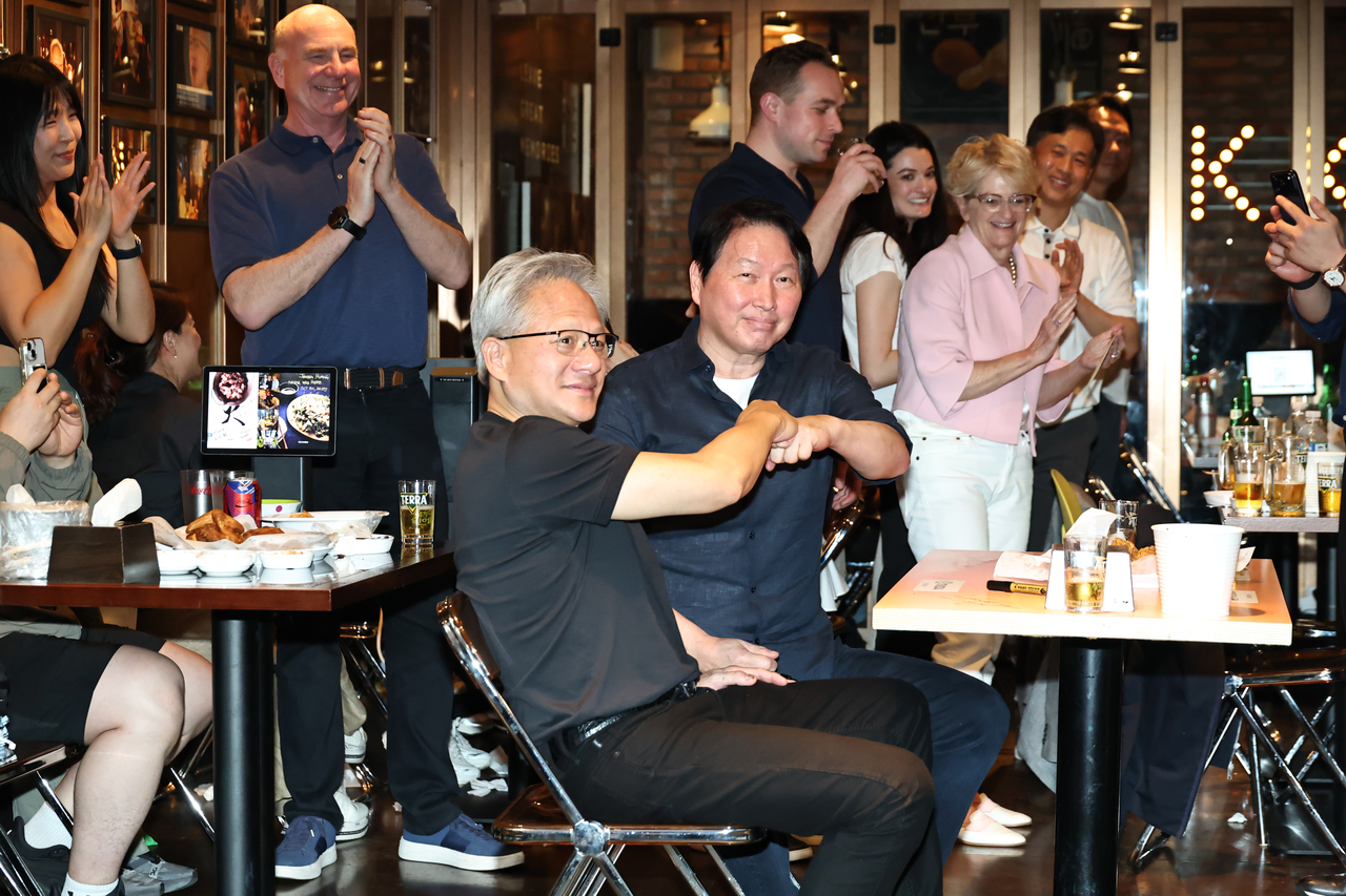 Nvidia Corp. CEO Jensen Huang (L) and SK Group Chairman Chey Tae-won bump fists during dinner at a chicken restaurant in southern Seoul on Sunday. (Yonhap)