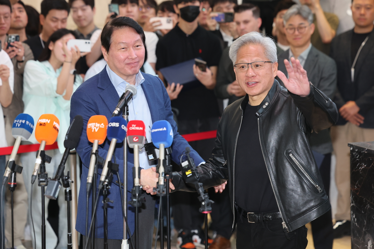Nvidia CEO Jensen Huang (right) shakes hands with SK Group Chairman Chey Tae-won after a joint briefing at SK Group’s headquarters in central Seoul on Monday. (Yonhap)