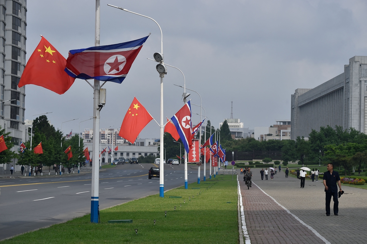 평양 시내 거리에 8일 북한의 인공기와 중국의 오성홍기가 나란히 걸려있다. 시진핑 중국 국가주석과 펑리위안 부부는 이날 정오께 평양 순안공항에 도착해 김정은 북한 국무위원장과 리설주 부부의 영접을 받고, 환영행사에 참석한 뒤 정상회담을 시작했다. [AFP]