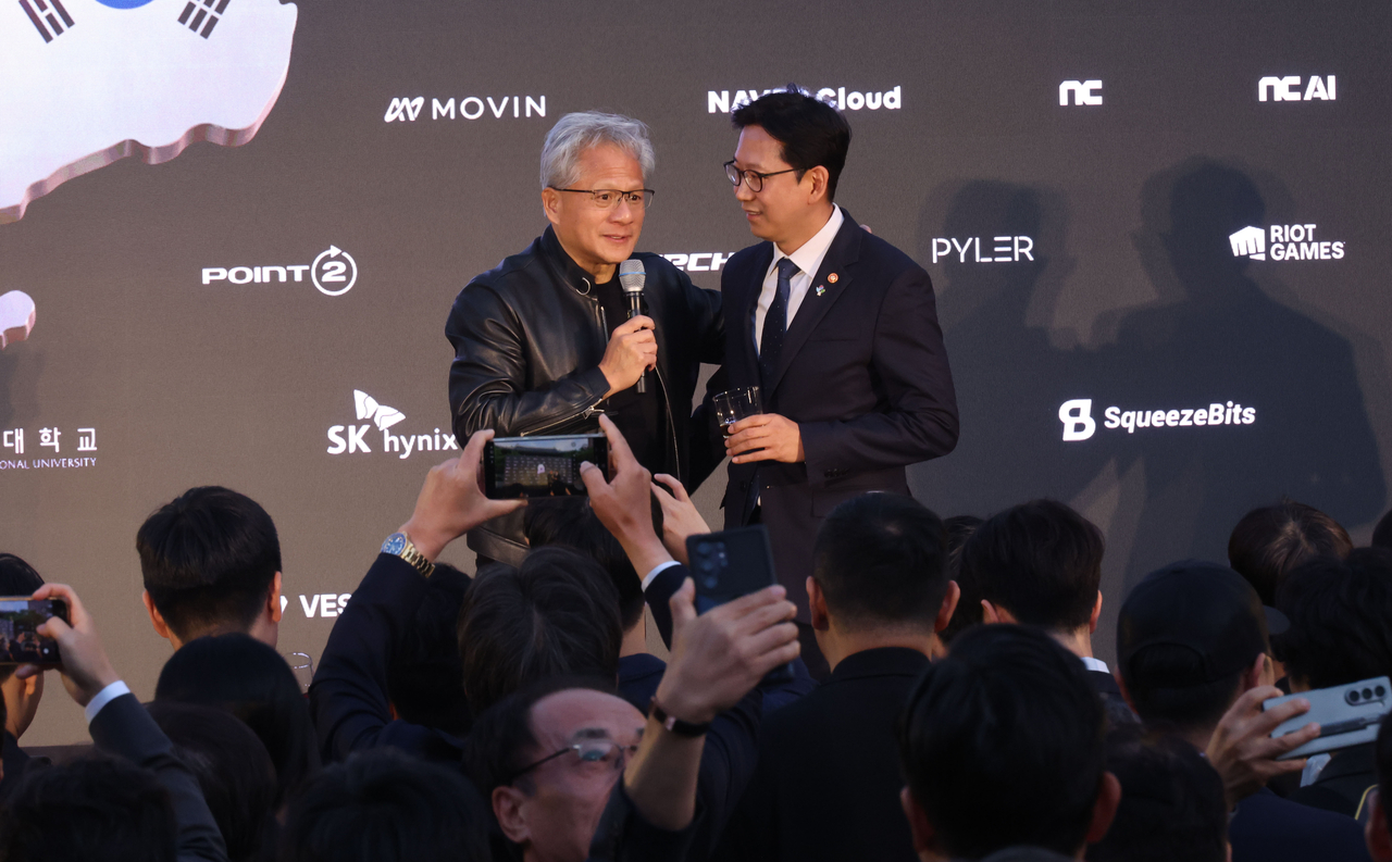 Nvidia CEO Jensen Huang (left) speaks during the Korea AI Ecosystem Reception in Seoul on Monday, attended by Science Minister Bae Kyung-hoon. (Yonhap)