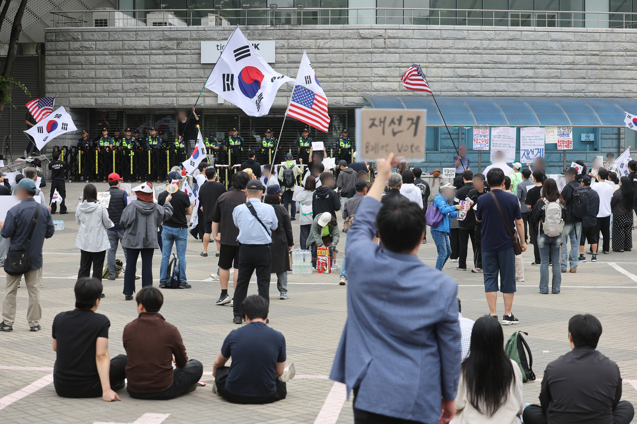 Protesters rally outside the SK Olympic Handball Gymnasium, which served as a vote-counting facility for the June 3 local elections, in southeastern Seoul on Monday. (Yonhap)