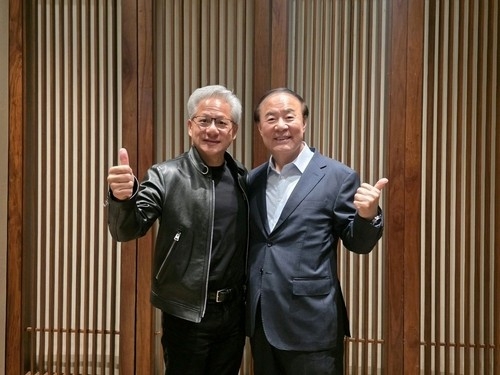 Jun Young-hyun (right), head of Samsung Electronics' device solutions division, poses for a photo with Jensen Huang, CEO of Nvidia Corp., at a hotel in Seoul on Monday, in this photo released by the South Korean tech giant. (Samsung Electronics)