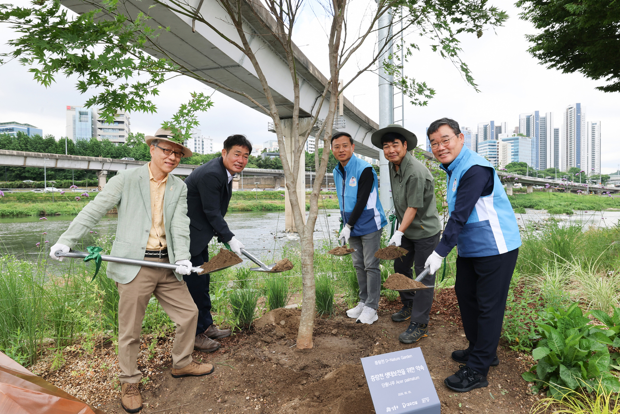 고광현 성동구 부구청장(왼쪽 두 번째), 김보현 대우건설 대표이사(오른쪽 첫 번째)를 포함한 참석자들이 지난 5일 단풍나무 식수 활동을 진행하고 있다. [대우건설 제공]