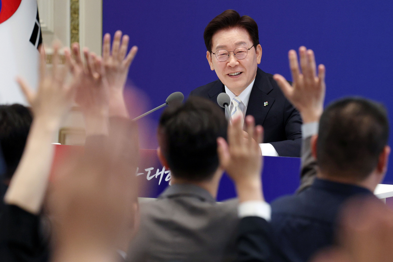President Lee Jae Myung takes questions from reporters during a press conference marking his first year in office at Cheong Wa Dae’s state guesthouse in Seoul on Monday. (Yonhap)