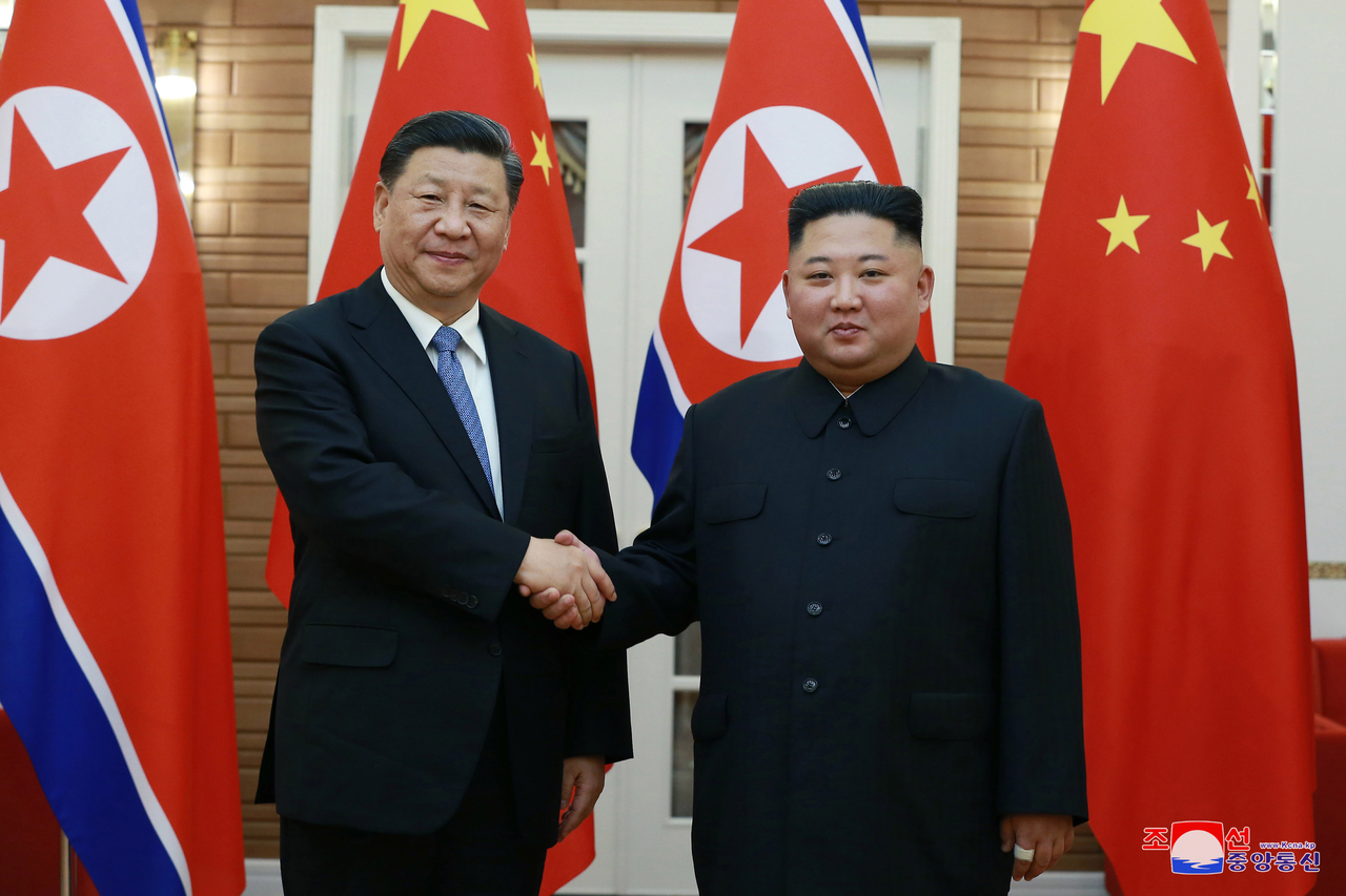 Chinese President Xi Jinping (L) shakes hands with North Korean leader Kim Jong-un prior to their summit talks in Pyongyang on June 20, 2019. (KCNA-Yonhap)