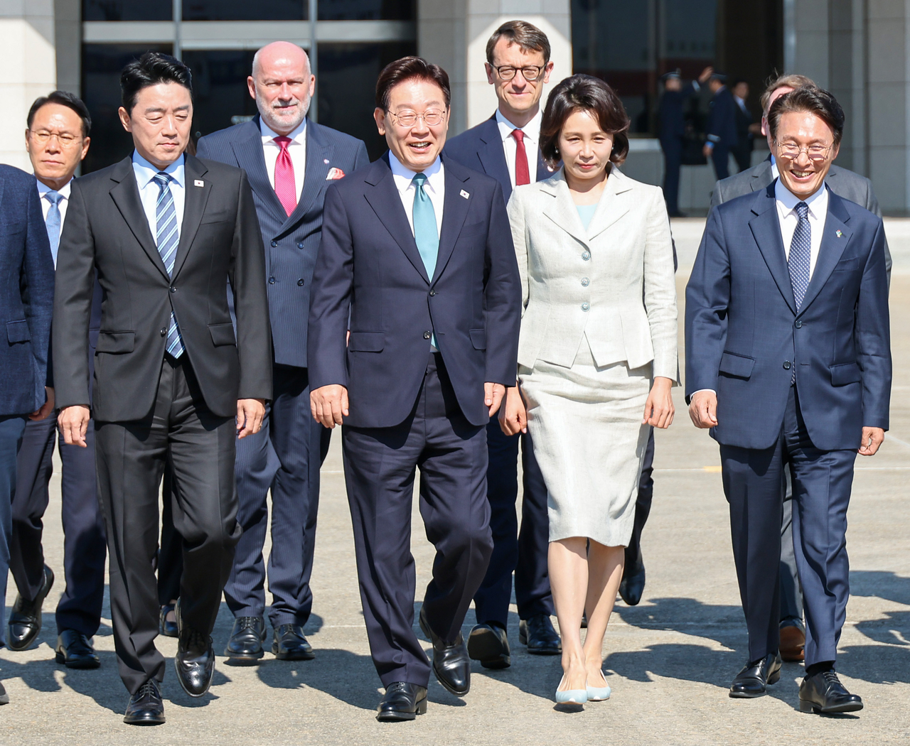 President Lee Jae Myung (C) and first lady Kim Hea Kyung (2nd from R) walk toward the presidential plane at Seoul Air Base, south of the capital, on Tuesday, to depart for a trip to Europe. (Yonhap)