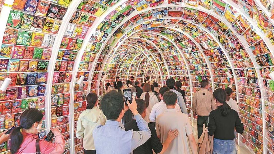 Shoppers navigate a tunnel made of snacks at Snack Kingdom, in Changsha, Hunan province.    (China Daily)