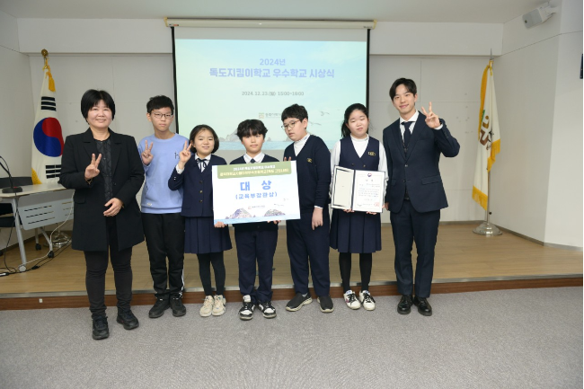 Hongdae University Elementary School teacher Lim Hyun-seo (right) poses with his students after his classes were recognized by the Education Ministry in 2024. (Lim Hyun-seo)