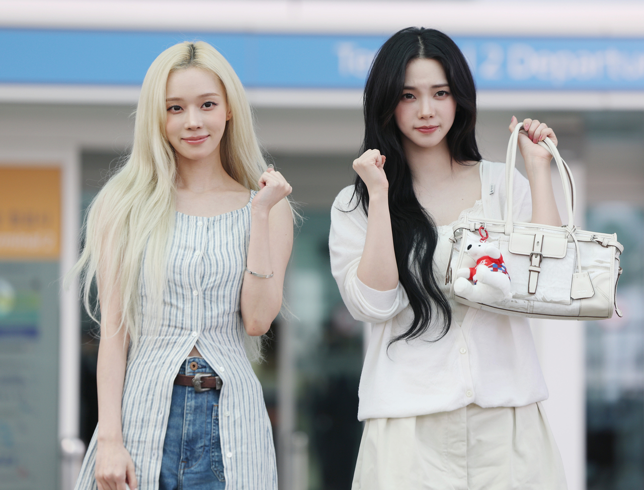 Winter (left) and Karina of Aespa pose for photos at Incheon Airport on Wednesday before departing for Mexico to support the Korean national football team at the 2026 FIFA World Cup. (Newsis)