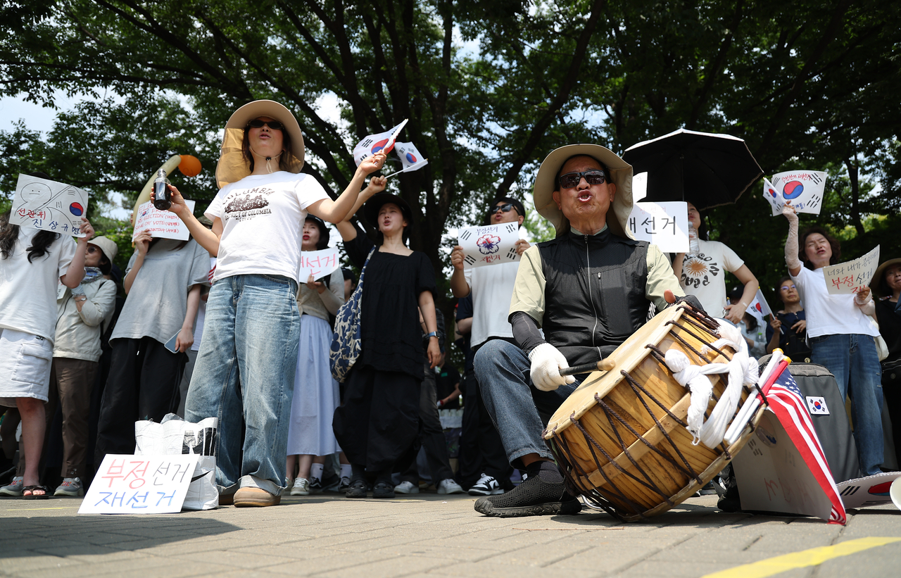 Protesters chant in front of the SK Olympic Handball Gymnasium in Songpa-gu, southern Seoul, on Tuesday, calling for a rerun of the June 3 local elections. (Yonhap)