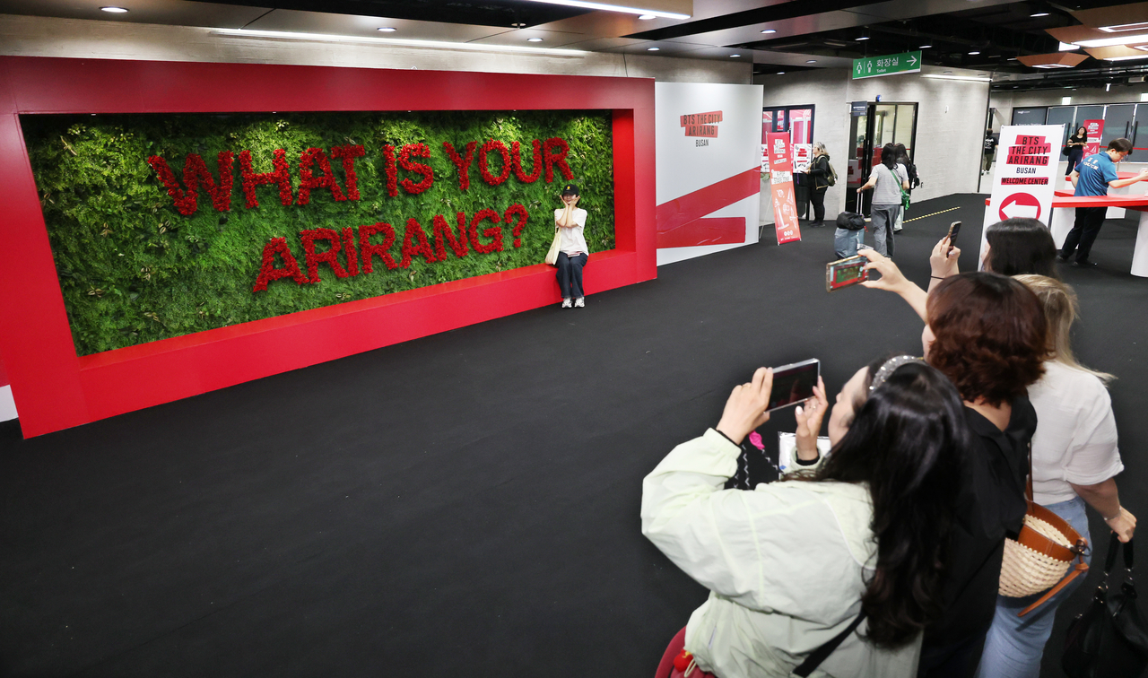 A visitor poses for a photo at the entrance of the BTS The City Arirang Busan Welcome Center after its opening at the Busan Eurasia Platform near Busan Station in Busan on June 5. (Yonhap)