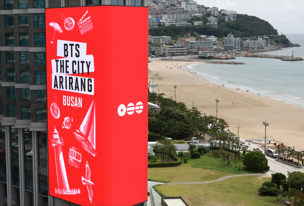 A media display on the exterior of Grand Josun Busan near Haeundae Beach broadcasts promotional content for "BTS The City Arirang — Busan" on Tuesday. (Yonhap)