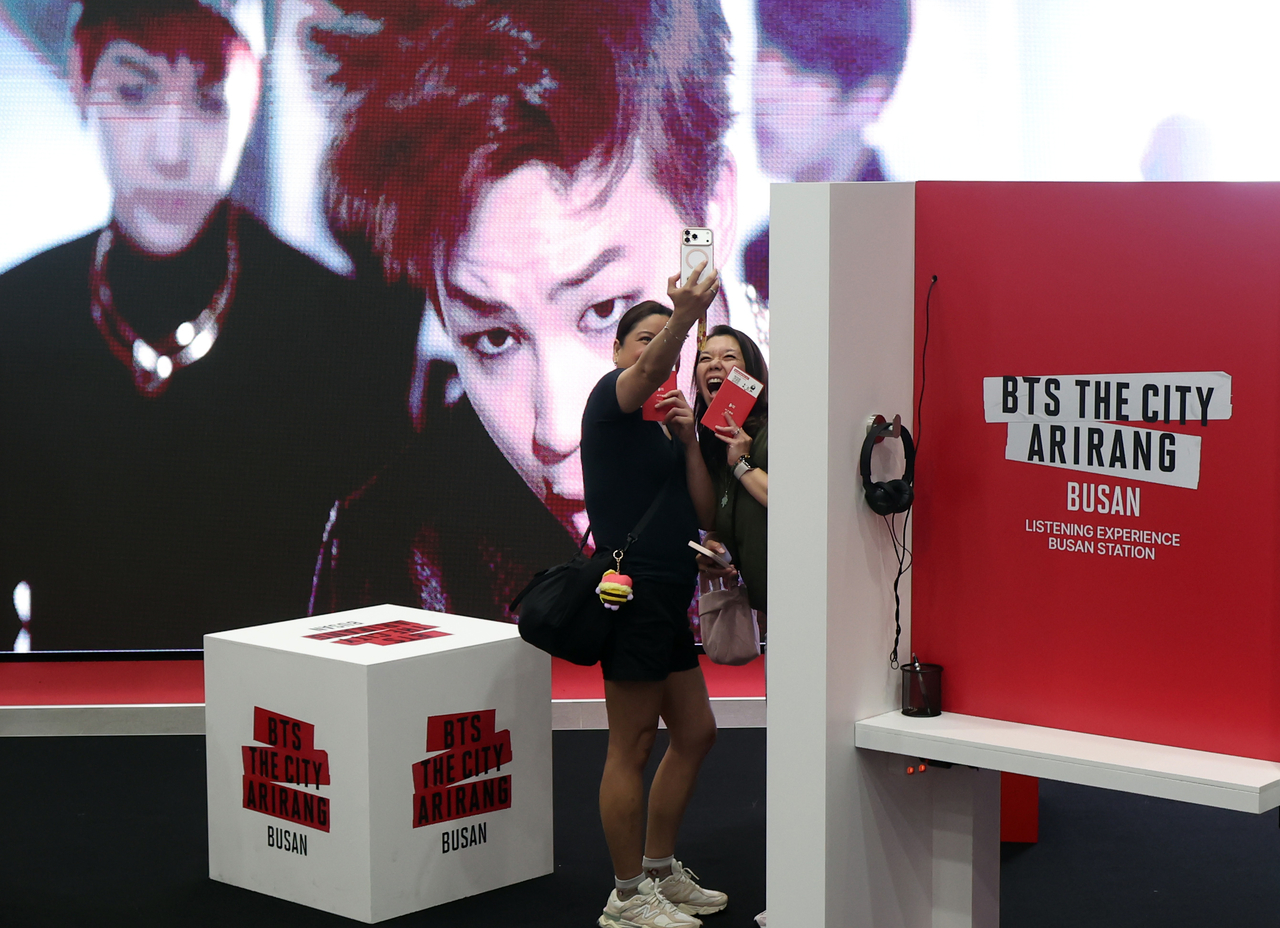 BTS fans take pictures at a welcoming center for fans installed at Busan Station as part of "BTS The City Arirang — Busan," Tuesday. (Newsis)