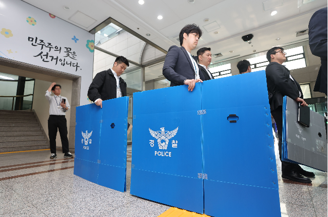 Police officials enter the National Election Commission headquarters in Gwacheon, Gyeonggi Province, on June 11 to conduct a search and seizure operation related to the ballot paper shortages during the June 3 local elections. (Yonhap)