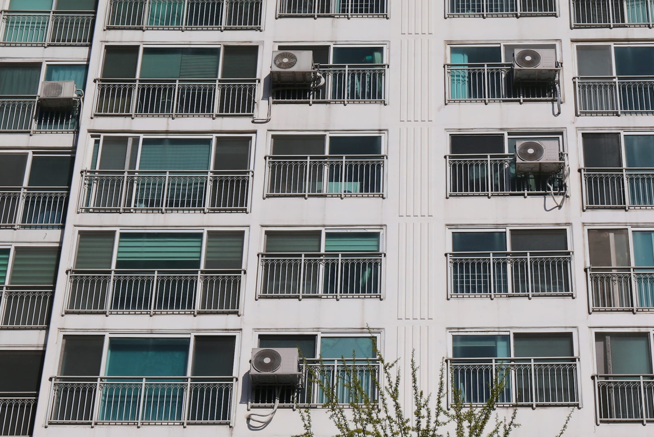 An apartment building in Suwon where outdoor air-conditioning units are installed on window railings (123rf)
