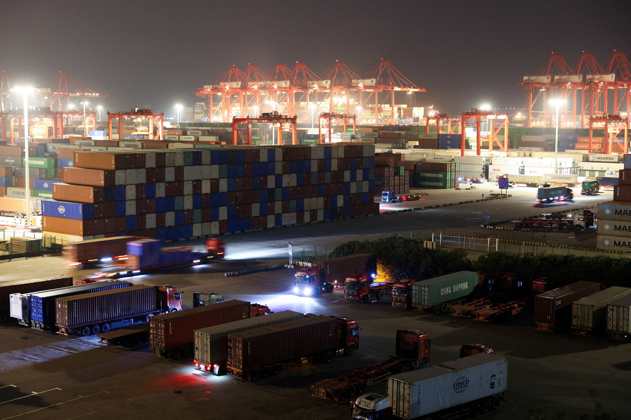 Shipping containers are stacked while semi-trucks are parked at Yangshan Port outside Shanghai, China, May 7. (Reuters-Yonhap)