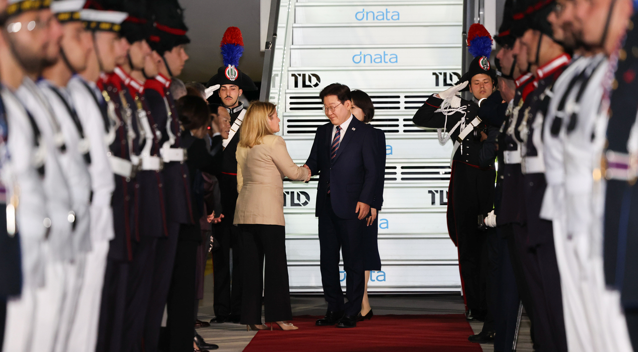 President Lee Jae Myung and First Lady Kim Hye Kyung greet an Italian official upon their arrival at Rome’s Fiumicino International Airport on June 10, 2026. (Yonhap)