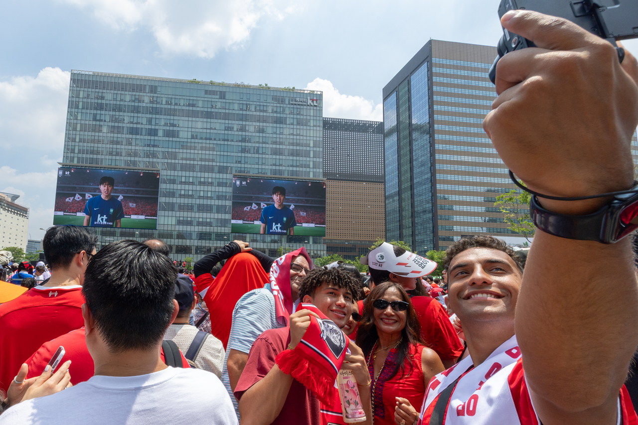 Fans pose for photos together in front of the media wall at KT's Gwanghwamun West building in Seoul, Friday. (KT)
