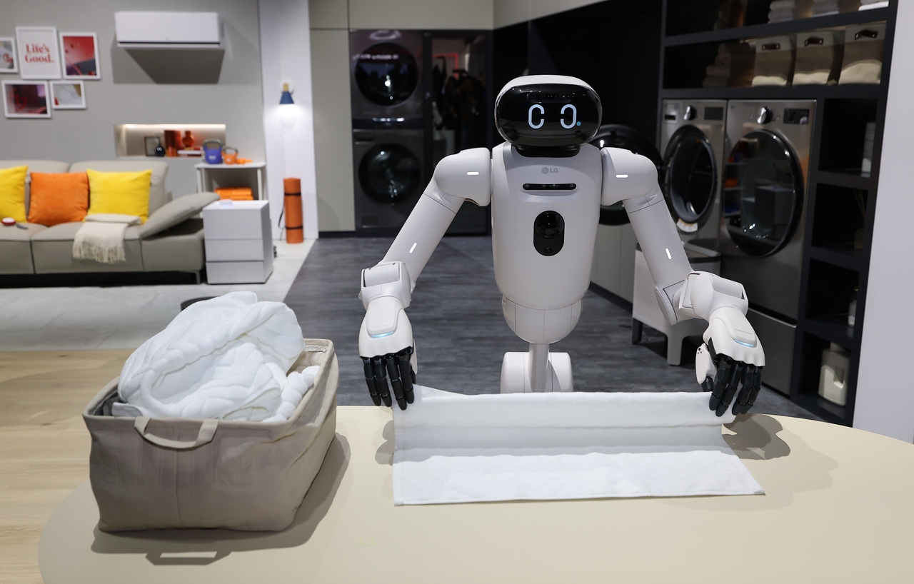 LG Electronics' home robot CLOiD folds a towel at the company's booth at the Las Vegas Convention Center in January ahead of CES 2026. (LG Electronics)