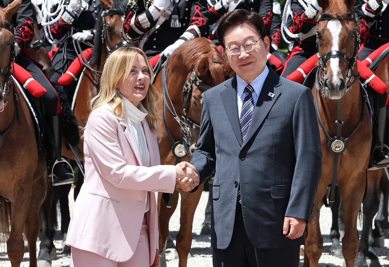 President Lee Jae Myung (right) shakes hands with Italian Prime Minister Giorgia Meloni in Rome on Friday, ahead of their talks. (Yonhap)