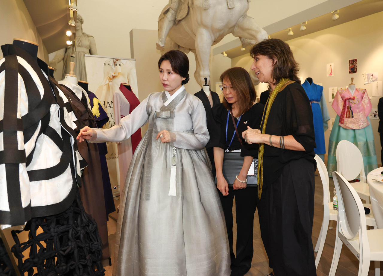 First lady Kim Hea Kyung, who accompanied President Lee Jae Myung on his state visit to Italy, looks at hanbok designs during a visit to the Academy of Fine Arts of Rome, where a creative hanbok fashion show was held, on Friday (local time). (Yonhap)