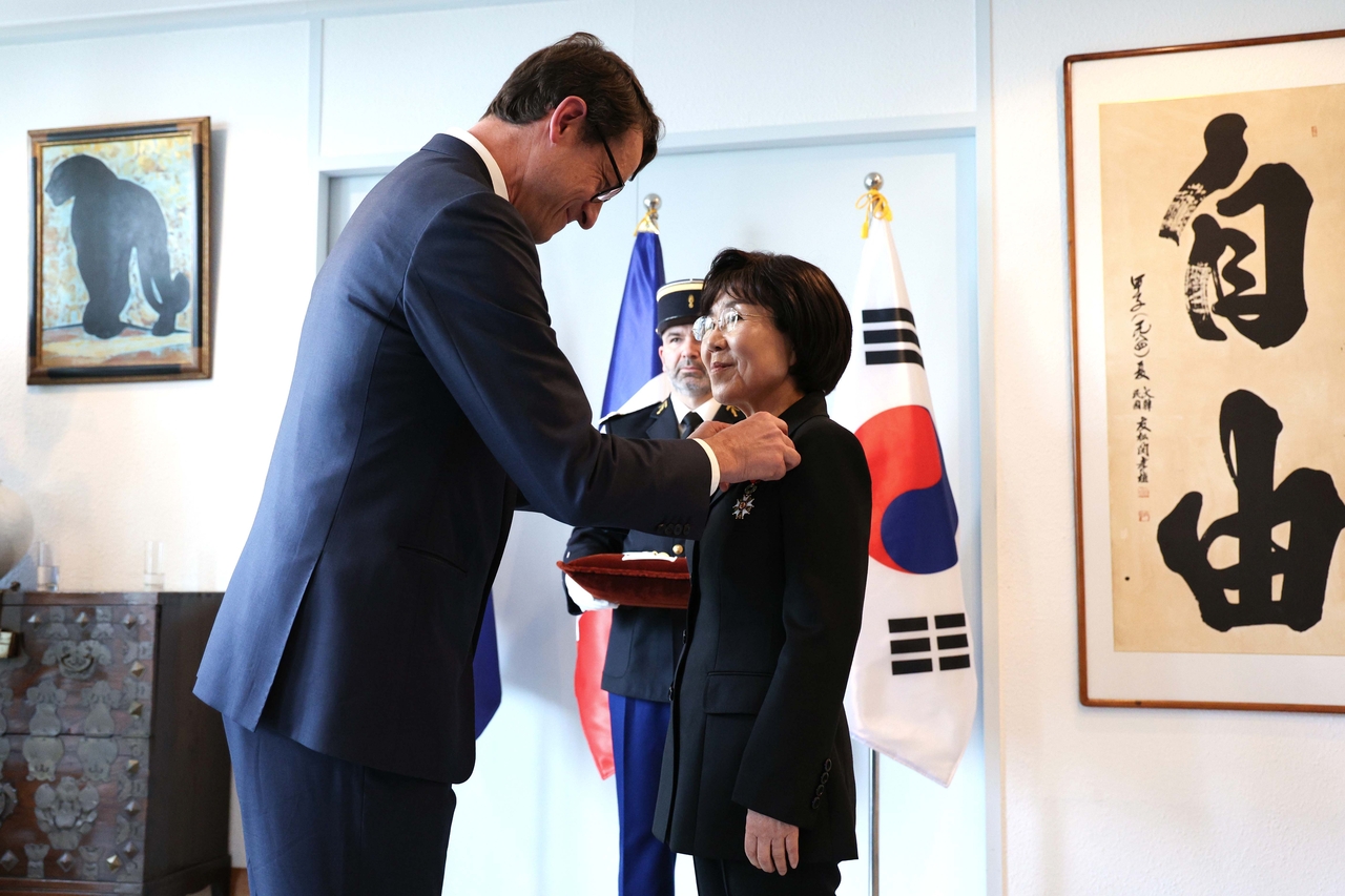 French Ambassador to Korea Philippe Bertoux (left) bestows the Officer of the Legion of Honor to Choi Jung-wha during an awards ceremony held at the French Embassy in Seodaemun-gu, on May 14, 2025. (Lee Sang-sub/The Korea Herald)