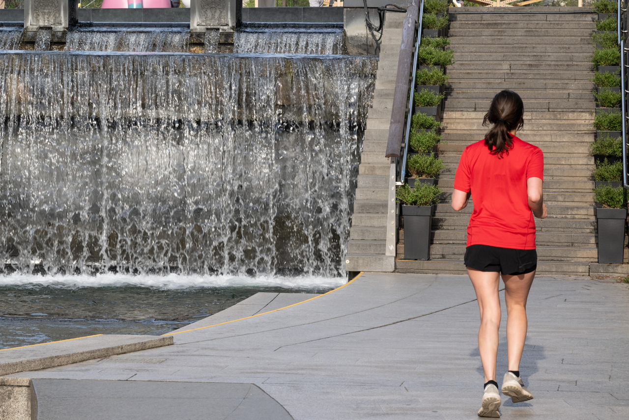 A woman runs alongside the Cheonggye Stream in Jung-gu, central Seoul, April 14. (Yoon Chang-bin/The Korea Herald)