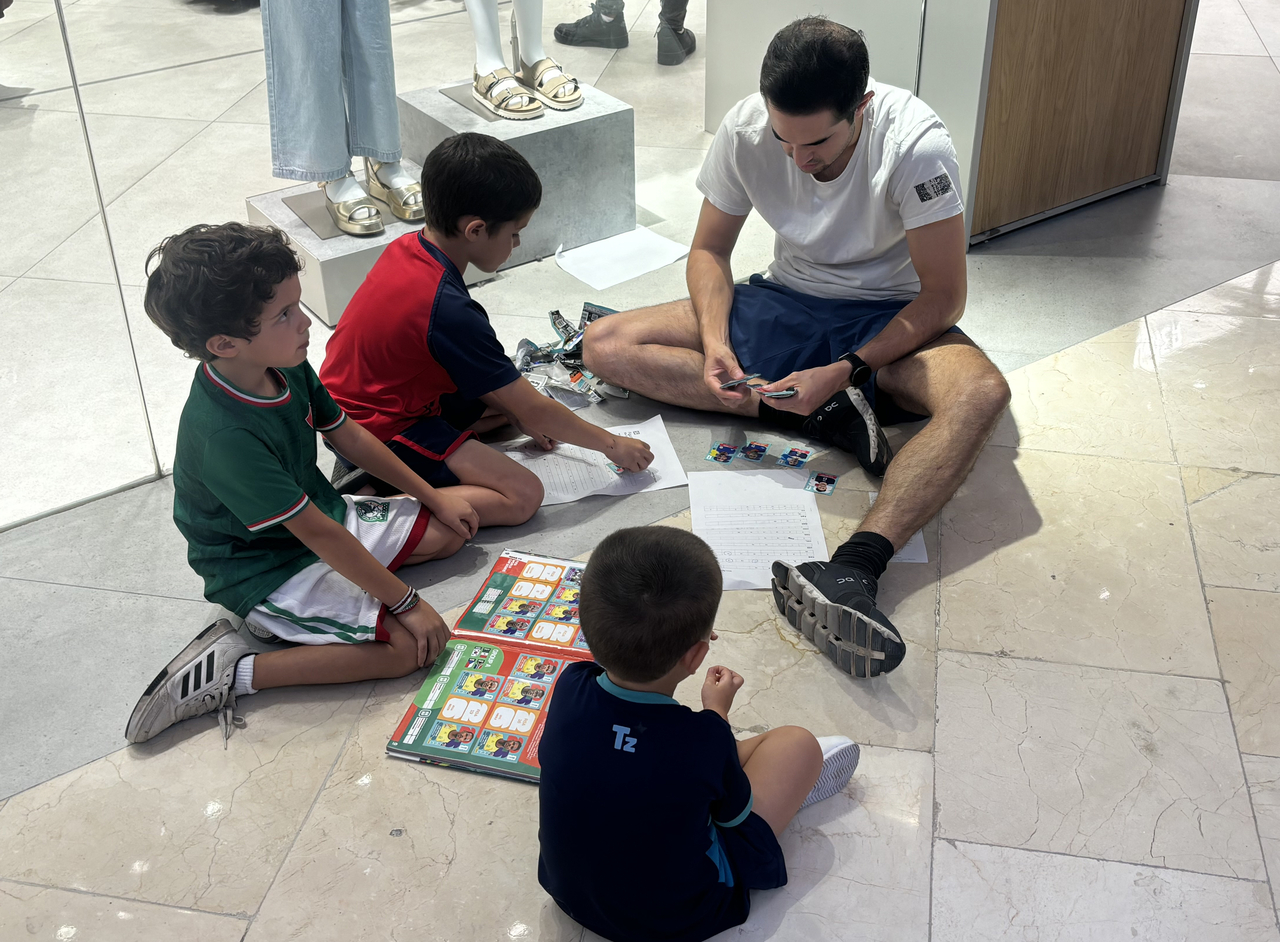 A family sits on the floor and looks through a Panini sticker album at Plaza Patria, a shopping mall in Zapopan near Guadalajara, Mexico, on Sunday. (Yonhap)