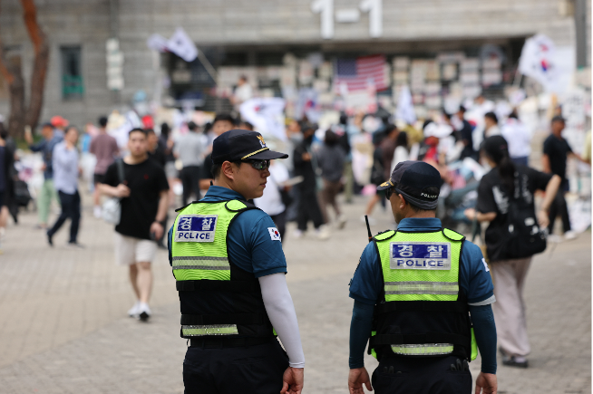 Police officers stand guard outside the SK Olympic Handball Gymnasium in Seoul's Songpa-gu, which had been used as a vote-counting center, as protesters continue their demonstrations Sunday over shortages of ballot papers in the June 3 lcoal elections. (Yonhap)
