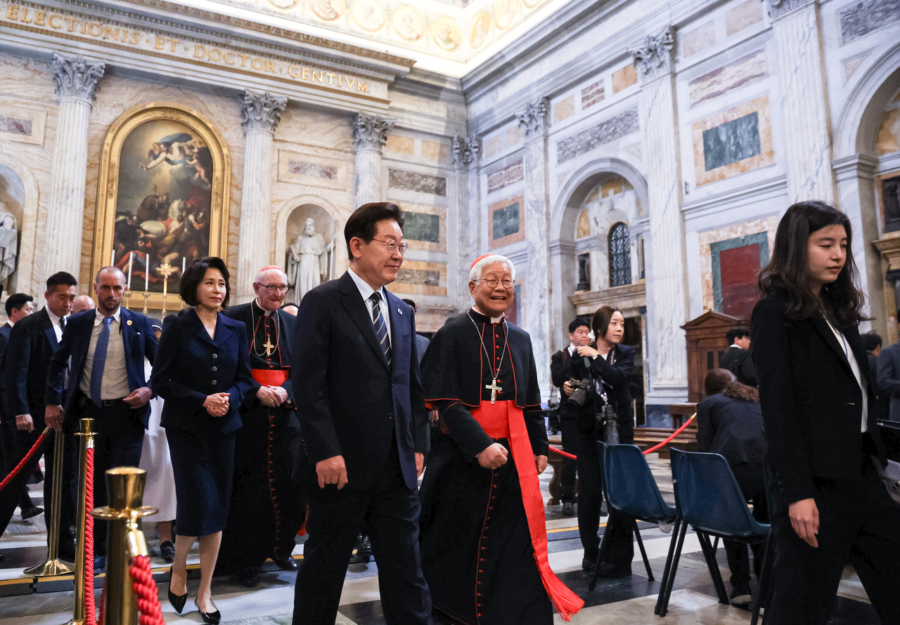 President Lee Jae Myung (center left, front) and Cardinal Lazarus You Heung-sik (center right, front) are seen on Sunday walking side by side to attend a special Mass in the Basilica of Saint Paul Outside the Walls, which is owned by the Holy See and is located in Rome, Italy. (Yonhap)